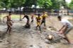 Мальчики играют в футбол во время дождя в Дакке, Бангладеш.