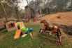 Детские игрушки рядом с домом, сгоревшим в результате пожара.