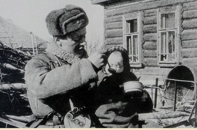 Воин Красной армии кормит ребёнка.