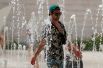 Турист освежается в городском фонтане в Лиссабоне, Португалия.