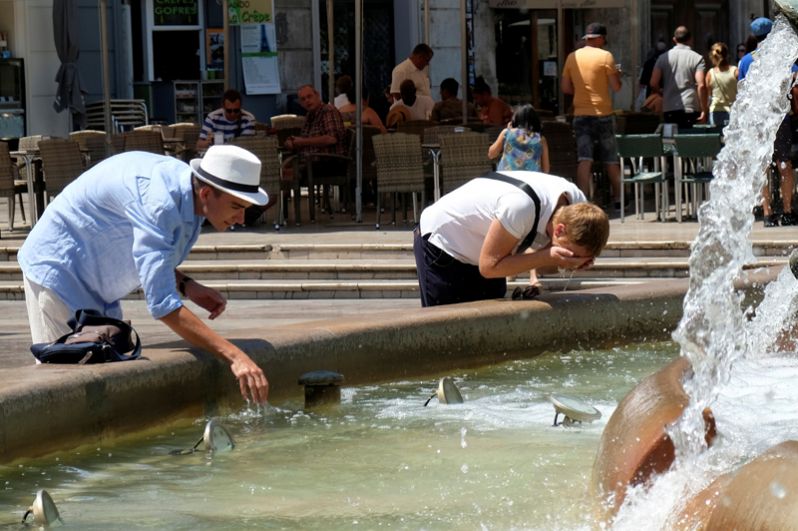 Туристы у фонтана на площади Святой Девы в Валенсии, Испания.