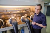 Вячеслав Авдин проводит научные исследования в четырёхперчаточном герметичном боксе - разрабатывает новые способы очистки сильно загрязнённой воды.