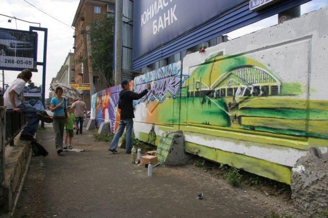 Некоторые заборы в центре Челябинска очистили от объявлений и украсили живописными граффити.