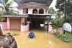 Мужчина во дворе своего дома во время наводнения в Алаппуже в штате Керала.
