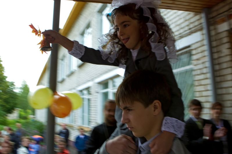 Первоклассница с колокольчиком на плече у старшеклассника школы села Пречистое Ярославской области.