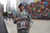 Сержант армии США с портретом своего двоюродного брата перед началом церемонии, посвященной 17-й годовщине терактов 11 сентября, Нью-Йорк.