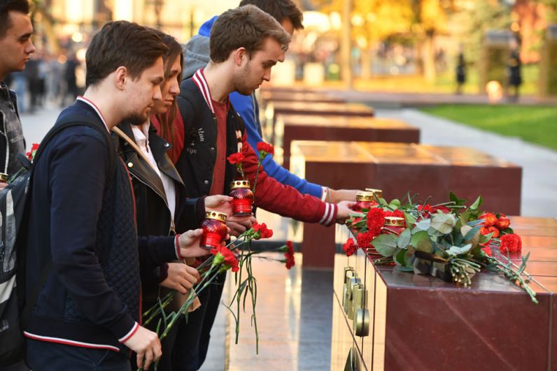 Люди возлагают цветы и ставят свечи на памятник городу-герою Керчи в Александровском саду в Москве в знак траура по погибшим при взрыве в колледже в Керчи.