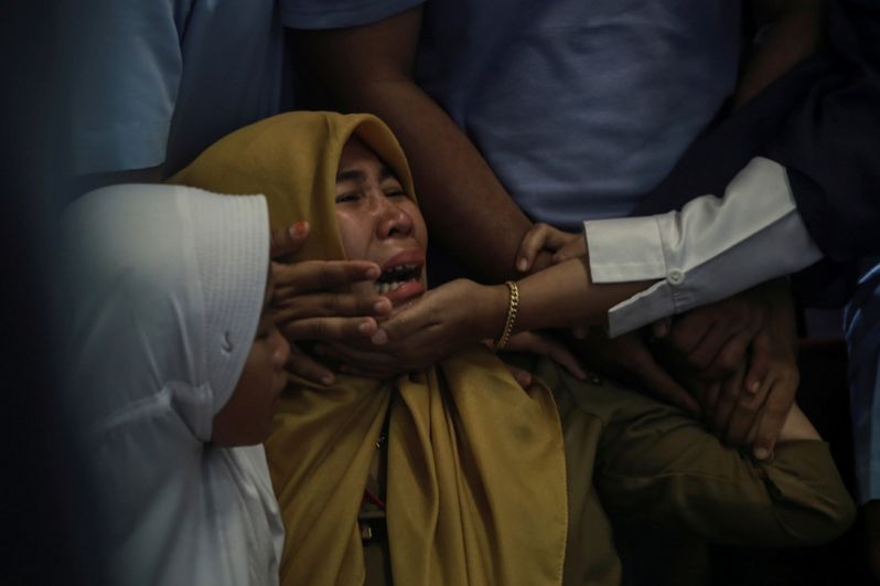 Родственники погибших в авиакатастрофе в аэропорту города Панкалпинанг.