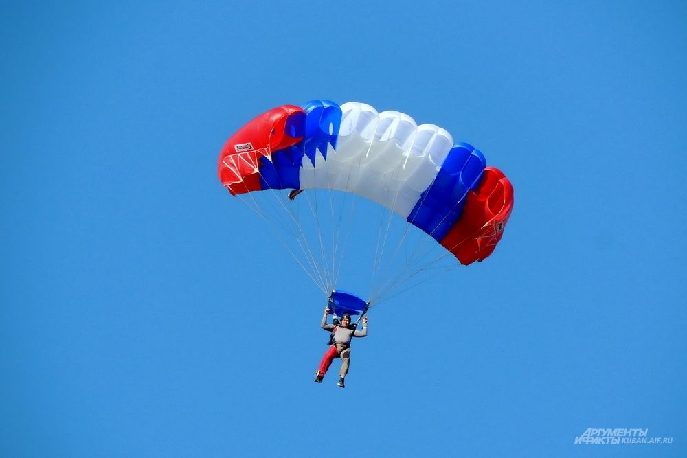 Спортсмен на парашюте типа «крыло» в цветах российского флага.