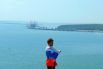 Открыт Крымский мост. На фото: женщина фотографируется с флагом России на фоне Крымского моста в Керчи.