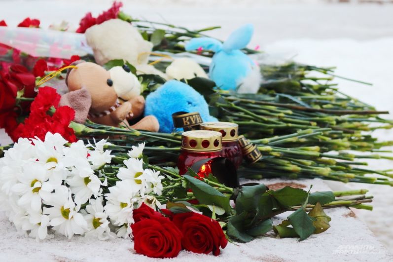 Вместе с цветами горожане несли игрушки - среди погибших есть несколько детей.