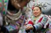 Женщины народа мяо в традиционных костюмах принимают участие в перетягивании каната на праздновании Нового года, Китай.