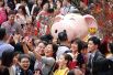 Посетители фотографируются с инсталляцией свиньи на цветочной ярмарке в преддверии нового года в Гуанчжоу, Китай.
