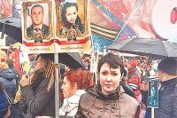 Анна Тув с фотографиями мужа и дочери, погибших от обстрела Горловки, на акции «Бессмертный полк» в Москве, 2017 г.
