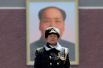 Военный стоит на страже перед портретом председателя Мао Цзэдуна на площади Тяньаньмэнь в Пекине.