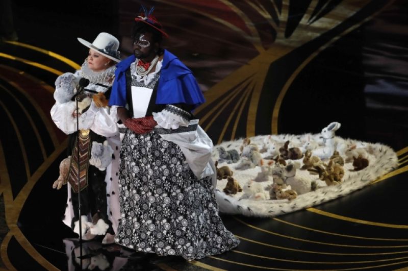 На сцене Мелисса МакКарти и Брайан Терри Хенри, в костюмах, навеянных «Алисой в стране чудес». Они вручили премию за лучший костюм.