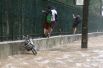 Местные жители на затопленной улице в районе Жардин-Ботанику в Рио-де-Жанейро.