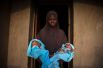 Мать держит на руках новорожденных близнецов, появившихся на свет четыре дня назад.