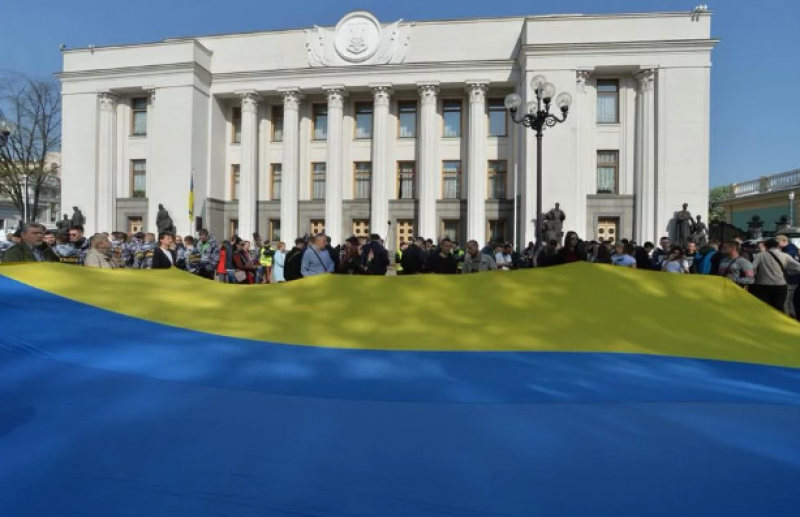 Под Радой в этот день собрались люди в поддержку законопроекта и развернули огромный флаг Украины.