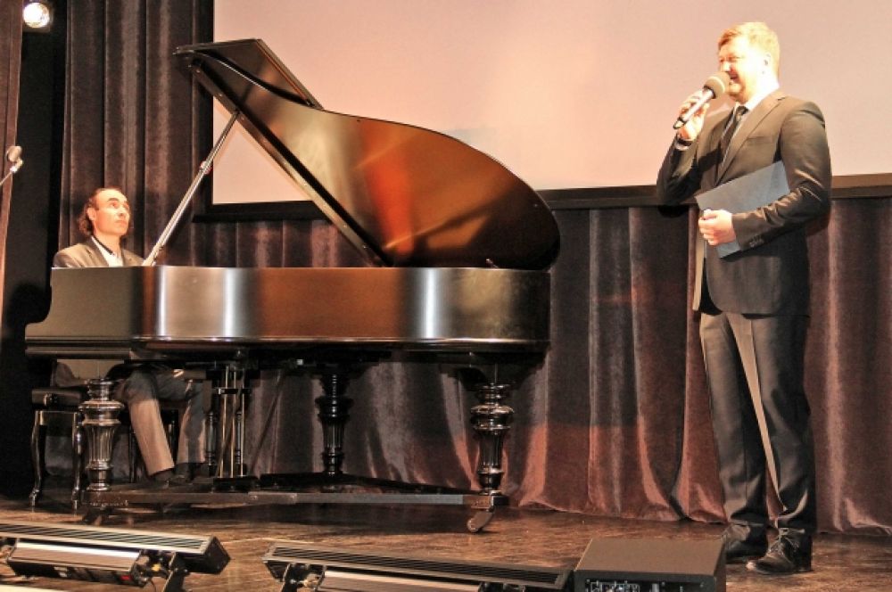 Ведущий мероприятия, артист «Петербург-концерта» Антон Денисов читает стихотворение под аккомпанемент пианиста Олега Вайнштейна.