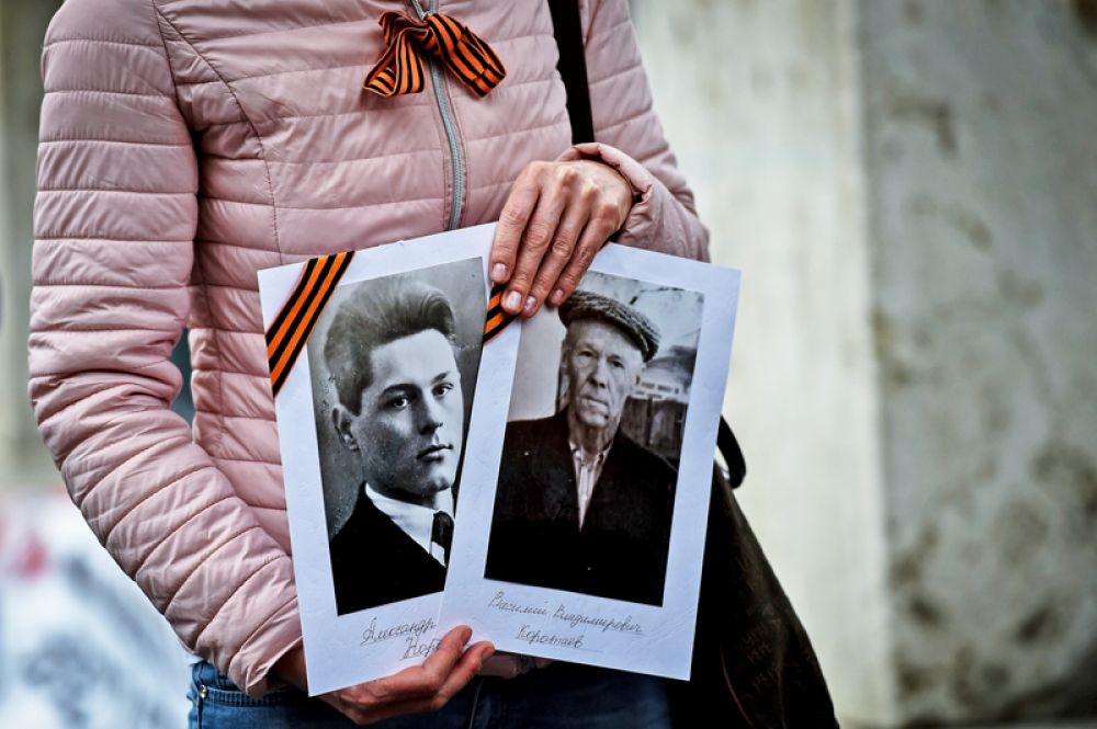 Фотографии в руках у участницы акции «Бессмертный полк» в Риме.