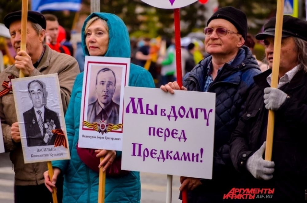 Люди несли в руках таблички с фотографиями своих родных, воевавших на фронте.