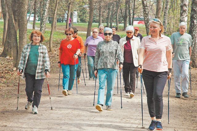 Преподаватель по скандинавской ходьбе Елена Адамян ведёт своих учеников по аллеям парка.