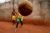 Молодая девушка играет в футбол с друзьями возле своего дома в Яунде. Камерунские женщины получили возможность обучаться у профессиональных тренеров в Rails Foot Academy.