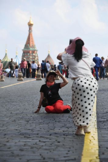 Туристы фотографируются на Красной площади.