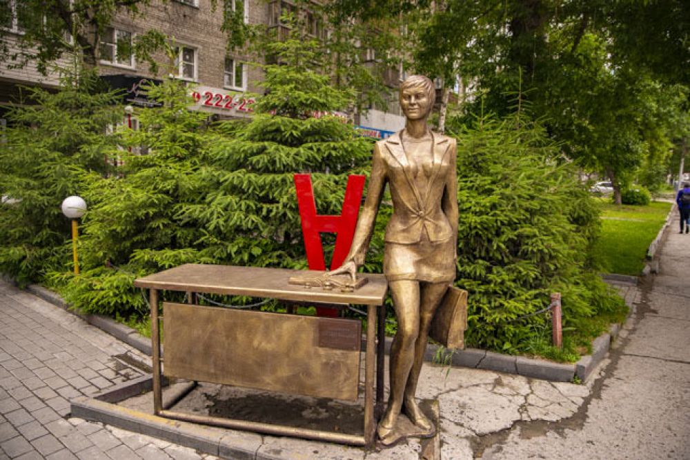 А эту важную даму точно не встретишь на рынке (смотри первое фото). Памятник деловой женщине расположен около дома №3 по улице Мичурина. Он сделан по заказу одной из компаний, расположенный в здании по этому адресу: не сложно догадаться, что руководит этой организацией женщина. Бизнес-леди одета в деловой костюм, держит в руках портфель и опирается на рабочий стол. В народе скульптуру называют памятником секретарю, карьеристке и даже учительнице: стол действительно напоминает школьную парту.