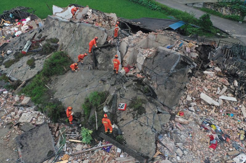 Спасатели на развалинах дома после землетрясения.
