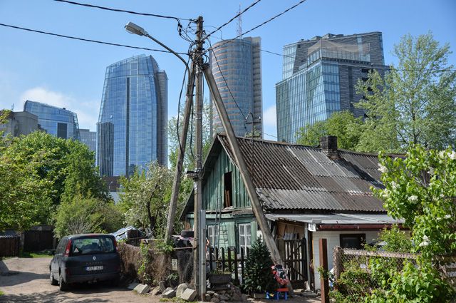 Контрасты Вильнюса: деревянный частный дом на фоне небоскребов в деловом районе.