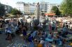 Люди отдыхают рядом с фонтаном на площади в Кельне.