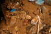 Личные вещи местных жителей лежат в грязи после сильного дождя в Тафалье.