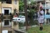 Женщина фотографирует затопленную улицу в Новом Орлеане, США.