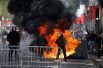 Столкновения демонстрантов с полицейскими на Елисейских полях после военного парада в День взятия Бастилии в Париже.