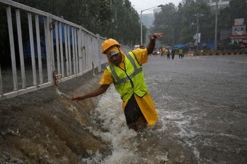 Волонтер на затопленной улице во время проливных дождей в Мумбаи.
