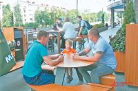 Летние кафе в районе посещают взрослые и дети.
