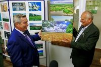 Виталий Дзюба вручает губернатору Ростовской области свою фотоработу.