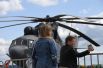 Посетительницы фотографируются на фоне Российского многоцелевого военно-транспортного вертолета Ми-26.