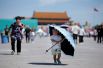 Мальчик с зонтом на площади Тяньаньмэнь в Пекине, Китай.