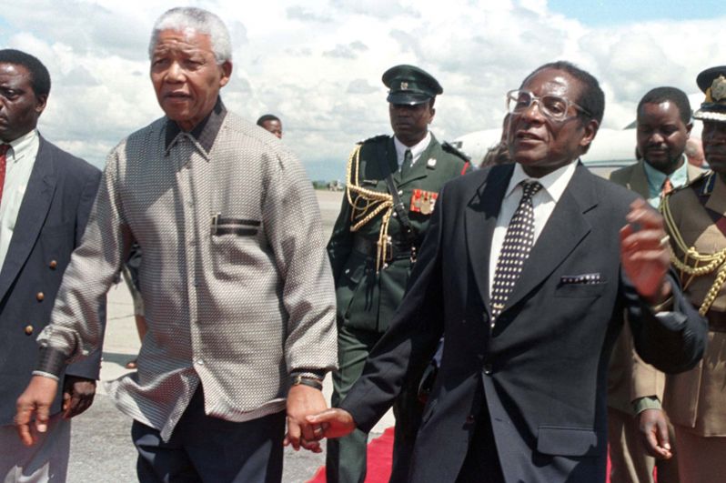Президент Зимбабве Роберт Мугабе с южноафриканским коллегой Нельсоном Манделой во время визита последнего в Зимбабве, 1998 год.