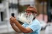 Бородатый мужчина делает селфи на набережной в преддверии урагана «Дориан» в Чарльстоне, США.