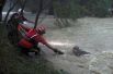 Спасатели помогают человеку выбраться из реки во время тропического шторма «Фернан» в муниципалитете Гуадалупа в штате Нуэво-Леон в Мексике.
