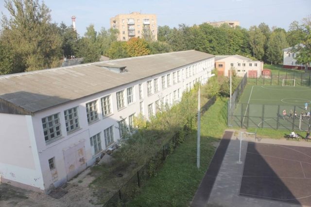Вид из окна школы №3: слева - пустующее здание, куда могла бы переехать начальная школа, справа - школьный стадион.