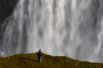 Турист делает селфи в зоне, где запрещено ходить, на фоне водопада Гульфосс в Исландии.