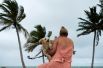 Женщина с собакой на пляже Ябукоа в Пуэрто-Рико перед приближением тропической шторма.