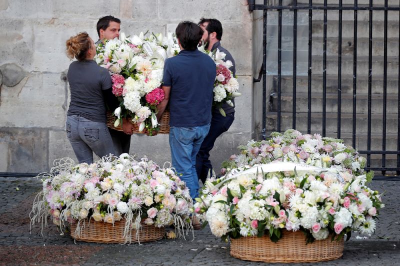 Люди несут цветы к церкви Сен-Сюльпис перед церемонией прощания с Жаком Шираком.