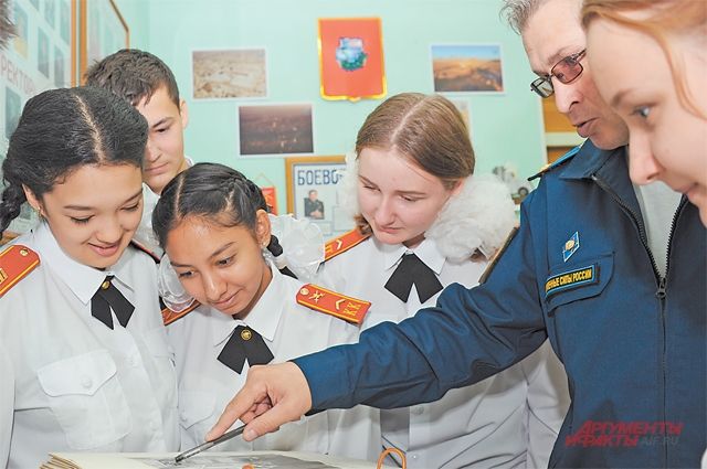 Ученики 9-го класса изучают альбом, хранящий факты из исторического прошлого Внукова, в школьном музее.