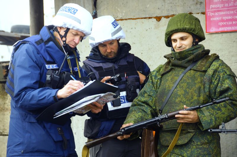 Наблюдатели ОБСЕ (слева) следят за отводом сил бойцов подразделений ЛНР в поселке Золотое в Луганской области.